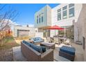 Spacious backyard with stylish outdoor furniture, a red umbrella, and a detached garage at 4351 Yates St, Denver, CO 80212