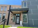 Modern home showcasing a brick and gray paneled facade with a covered entryway and manicured front lawn at 4351 Yates St, Denver, CO 80212