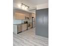 Modern kitchen with stainless steel appliances, light wood cabinets, and a gray luxury vinyl tile flooring at 603 Inca St # 429, Denver, CO 80204