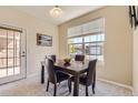 Cozy dining area with dark wood table set and natural light streaming in from large window at 7440 S Blackhawk St # 4-102, Englewood, CO 80112