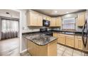 Stylish kitchen with light wood cabinets, dark granite countertops, and stainless steel appliances at 1691 Poplar St, Denver, CO 80220