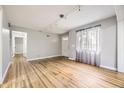 Spacious living room with hardwood floors, neutral paint, and large windows filling the room with natural light at 1691 Poplar St, Denver, CO 80220