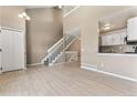 Inviting living room with wood floors, soaring ceilings, staircase, and seamless flow into the adjacent kitchen area at 11542 Community Center Dr # 56, Northglenn, CO 80233