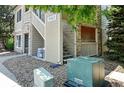 A view of the condo exterior with an exterior stairway, and rock landscaping at 9963 E Carolina Cir # 104, Aurora, CO 80247