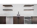 Close up of bar area with floating shelves, modern sink, dishwasher, and sleek wine fridge at 4238 Zuni St, Denver, CO 80211