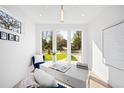 Bright home office with large windows offering serene views, modern white desk, and comfortable blue seating at 4238 Zuni St, Denver, CO 80211