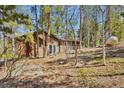 Exterior view of home surrounded by trees, featuring a walkout basement and natural landscaping at 11798 Ridge Rd, Golden, CO 80403