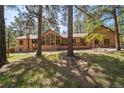 Exterior of a home featuring large windows, wood and stone elements, and a deck at 5846 S Pike Dr, Larkspur, CO 80118