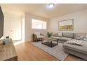 Open concept living room with gray sectional sofa and wood-look floors at 2131 Coronado Pkwy # A, Denver, CO 80229