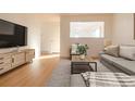 Open concept living room with gray sectional sofa and wood-look floors at 2131 Coronado Pkwy # A, Denver, CO 80229