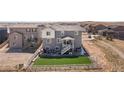Aerial view of home with fire pit, patio, lush backyard, and white fence, set in a well-maintained community at 17851 Herrera Dr, Parker, CO 80134