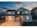 Charming two-story home with a three-car garage, well-manicured lawn, and inviting front porch at 17851 Herrera Dr, Parker, CO 80134