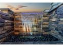 Stylish stone water feature with a modern waterfall design and accent lighting at 17851 Herrera Dr, Parker, CO 80134