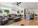 Open-concept living room featuring hardwood floors, modern decor, and a stylish kitchen at 1299 Newton St, Denver, CO 80204