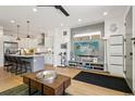 Bright living space with hardwood floors, kitchen island, and TV area with gray wood paneling at 1299 Newton St, Denver, CO 80204