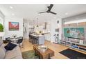 Open-concept living space with hardwood floors, modern decor, kitchen with island and dining area at 1299 Newton St, Denver, CO 80204