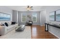 Bright living room with hardwood floors, a plush rug, and windows letting in natural light at 10204 Ridgegate Cir, Lone Tree, CO 80124