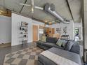 Living room and kitchen area features exposed ductwork, concrete ceiling and an open floor plan at 2100 16Th St # 204, Denver, CO 80202
