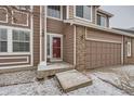 Inviting front entrance with red door, brick accents, and a covered porch at 560 Hampstead Ave, Castle Rock, CO 80104