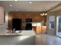 Kitchen with light wood cabinets, black appliances, and a breakfast bar at 560 Hampstead Ave, Castle Rock, CO 80104