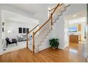 Bright foyer with hardwood floors and a staircase leading to the second floor, connecting to living spaces at 6232 W Cross Dr, Littleton, CO 80123