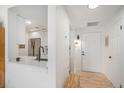 Bright entryway featuring a modern white door, hardwood floors, and a view of the kitchen at 180 Cook St # 406, Denver, CO 80206