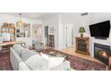 Cozy living room featuring a fireplace, modern sofa, and an adjacent view into the updated kitchen at 180 Cook St # 406, Denver, CO 80206