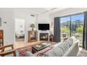 Inviting living room with a cozy fireplace, modern sofa, and access to the balcony with neighborhood views at 180 Cook St # 406, Denver, CO 80206