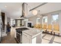 Open kitchen with island, stainless hood, modern lighting, and adjoining dining area at 4457 Wyandot St, Denver, CO 80211