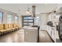 Bright, open kitchen with granite island, modern hood vent, and view of outdoor garage door at 4457 Wyandot St, Denver, CO 80211