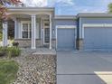 Charming blue home with a well-manicured front yard, featuring a two-car garage at 17284 E Hawksbead Dr, Parker, CO 80134