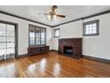 Bright living room with hardwood floors, a brick fireplace, and large windows, offering a comfortable and inviting space at 2933 Benton St, Wheat Ridge, CO 80214