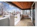 Inviting covered porch with a swing, wood ceiling, and pillars, creating a cozy outdoor seating area at 2933 Benton St, Wheat Ridge, CO 80214
