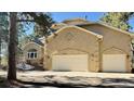 Charming home features a stucco facade, two-car garage, and well-manicured front yard at 19850 Indian Summer Ln, Monument, CO 80132