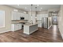 Modern kitchen with hardwood floors, white cabinets, stainless steel appliances, and a center island with bar seating at 5909 S Platte Canyon Dr, Littleton, CO 80123