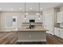 A kitchen featuring stainless steel appliances, white cabinetry, a center island, and pendant lighting fixtures at 5909 S Platte Canyon Dr, Littleton, CO 80123
