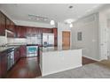 Open kitchen showcasing a large island with granite countertop, stainless steel appliances, and wood cabinetry at 13598 Via Varra # 105, Broomfield, CO 80020