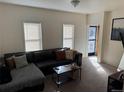 Inviting living room with a comfortable black sofa, carpeted floors, and bright natural light at 2469 Ames St, Edgewater, CO 80214
