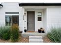 Close-up view of the front entrance, showcasing a gray door and decorative plants at 10254 Worchester St, Commerce City, CO 80022