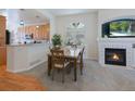 Cozy dining room adjacent to kitchen featuring fireplace, large window, and carpet floors at 6 Woodland Cir, Highlands Ranch, CO 80126