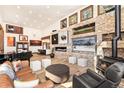 Bright living room featuring a stone accent wall, gas fireplace, wood stove, and comfortable seating at 94 Lake View Dr, Breckenridge, CO 80424