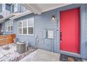 Close up on a blue townhome with a bright red front door and snowy yard at 6211 W 28Th Ct, Wheat Ridge, CO 80214