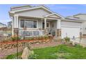 Beautifully landscaped yard with green grass, stone accents and a inviting porch with flower pot decor at 9674 Fox Den Dr, Littleton, CO 80125