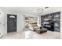 Living room featuring marble tile floors, fireplace, and large windows at 555 Everett St, Lakewood, CO 80226