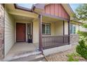 Inviting front porch with a brown door, stone accents, and manicured landscaping at 5770 Waverley Ave, Firestone, CO 80504