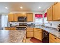 Well-lit kitchen featuring wooden cabinets, stainless steel appliances, and durable countertops at 5770 Waverley Ave, Firestone, CO 80504
