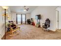 Spacious living room with carpet flooring, a ceiling fan, and ample natural light from the large windows at 5770 Waverley Ave, Firestone, CO 80504