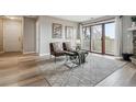 Bright living room showcasing balcony access, neutral paint, wood floors, and contemporary furnishings at 7468 S Alkire St # 204, Littleton, CO 80127