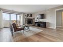 Cozy living room featuring a stone fireplace, balcony access, and modern furnishings at 7468 S Alkire St # 204, Littleton, CO 80127