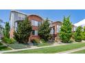 A row of brick townhomes featuring lush landscaping and modern design elements at 84 Spruce St # 707, Denver, CO 80230